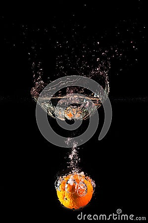 ORANGE FALLING INTO WATER Stock Photo