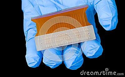 Orange flexible circuit board in human hand on black background Stock Photo
