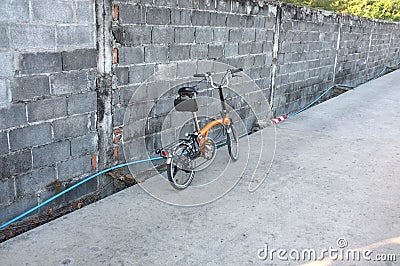 Orange folding bicycle on the road Stock Photo