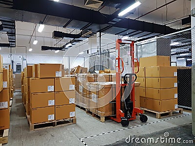 Orange fork lifter work in big warehouse Stock Photo