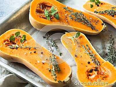Orange fresh pumpkin cooking with spice and herbs. cut pumpkin slices on a baking sheet. Fresh orange muscat gourd cut in half, re Stock Photo