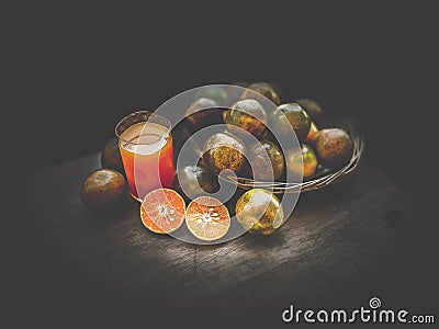 Orange fruits and squeezed orange juice in dark scene Stock Photo
