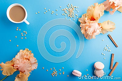 Orange iris flowers and a cup of coffee on a blue pastel background Stock Photo