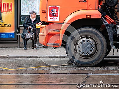 Orange irrigation sweepers truck stand on the tram tracks. Moscow coat of arms. Cityscape Editorial Stock Photo