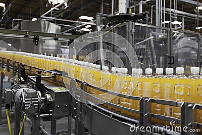 Orange juice bottles on conveyor in bottling plant Editorial Stock Photo