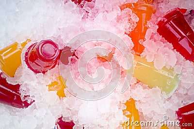 Orange juice and colorful sweet water on ice crystals Stock Photo