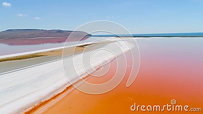 Orange lake in Crimea. Shot. Top view of bright orange lake water against white sand. Extraterrestrial landscape of Stock Photo