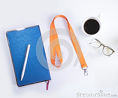 Orange Lanyard Neck Strap, Blue notebook paper, Metal silver pen on white desk Stock Photo