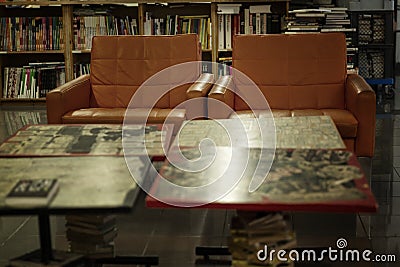 Orange leather chairs in a library with wooden bookcases. Knowledge and education. Blurred Stock Photo