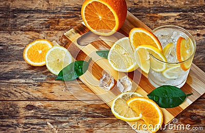 Orange, lemon, leaves, glass homemade lemonade and ice Stock Photo