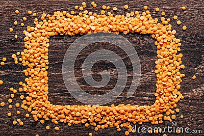 Orange lentils nicely laid out on a wooden background. Top view. rectangular copy space. Vegetarian food. Unprepared Stock Photo