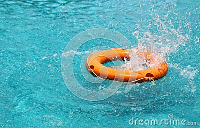Orange life buoy splash water in the blue swimming pool Stock Photo