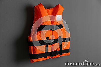 Orange life jacket on grey background. Personal flotation device Stock Photo