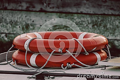 orange life rings stacked on the deck of a boat or yacht Stock Photo