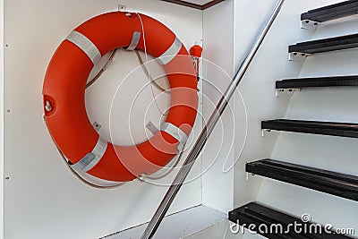 Orange lifebuoy hanging on the wall at the exit Stock Photo