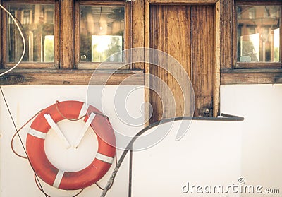 Orange lifebuoy on vintage white boat in port Stock Photo