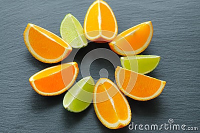 Orange and lime sliced segments on black slate stone. Vitamin concept Stock Photo