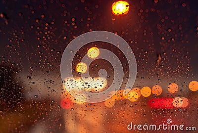 Orange night light bokeh from street light on traffic jam day. Rainy day. Transparent glass window with rain drop. Romantic Stock Photo