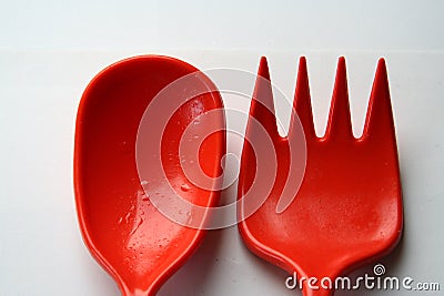 Orange and oily salad fork and spoon Stock Photo