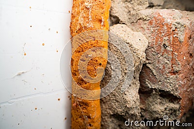 Orange old polyurethane foam between wall and plastic window close-up Stock Photo