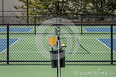 Orange Paddle and Yellow Ball at Pickleball Complex Stock Photo