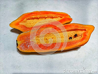 an orange papaya that is split into two parts Stock Photo