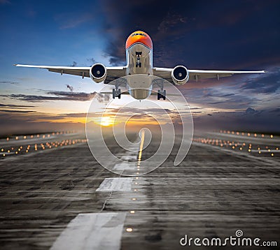 Orange passenger plane takes off from the airport runway during the sunset Stock Photo