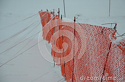 Orange perforated plastic PE foil barriers against snow in mountain areas. slow down the speed of snow, forming tongues and dune b Stock Photo