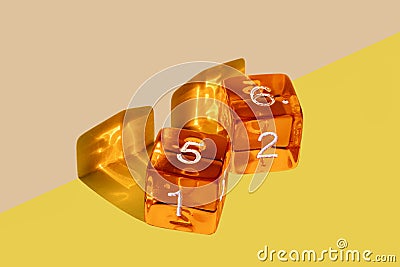 Orange plastic dice on a yellow background with the winning come out roll corresponding to a die with the number 5 and a die with Stock Photo