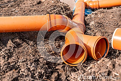 orange plastic PVC pipes in the ground Stock Photo