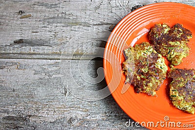 Orange Plate On Wooden Table Full Of Cauliflower And Broccoli Pancakes Stock Photo