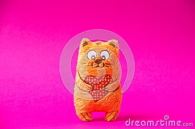 Orange plush cat with red heart so cute on the pink background Stock Photo