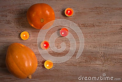 Orange pumkins with colorful candles on the wooden boards. Stock Photo