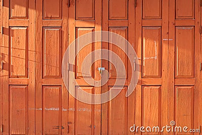 Orange retro thai wooden folding door with lock under evening sunlight Stock Photo