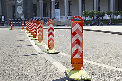 Orange road dividers. Curved line of dividing posts on the double road marking line Stock Photo