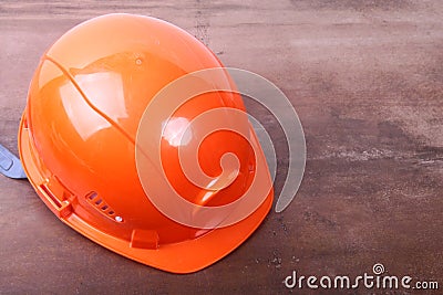 Orange safety engineer helmet on brown background Stock Photo