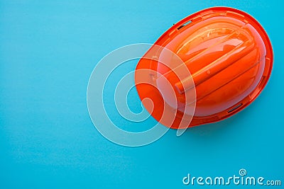 Orange safety helmet on blue background - Construction industry Stock Photo