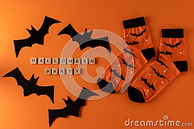 Orange socks with bats. Clothing costume for Halloween party. Cheerful bright multicolored sock top view. Stock Photo