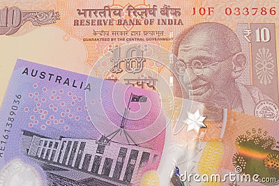A orange ten rupee bill from India paired with a colorful five dollar bill from Australia. Stock Photo