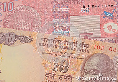 A orange ten rupee bill from India paired with a red ten taka bank note from Bangladesh. Stock Photo