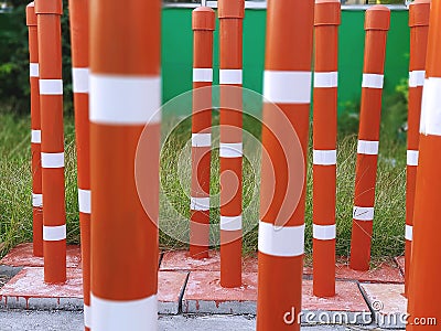 Orange Traffic Pillars in Rows Beside Grass Field Stock Photo