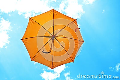 Orange umbrella flying on blue sky Stock Photo