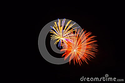 Orange, yellow, blue and pink fireworks shine bright in the sky Stock Photo