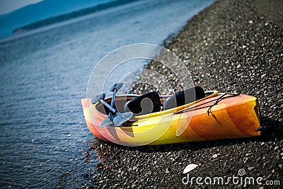 Orange and Yellow Kayak With Oars on the Sea Shore Stock Photo