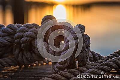 Orange and yellow sky above harbor port sunset rope Stock Photo