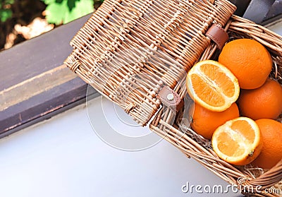 Oranges in the basket on the wimdow sill in summer Stock Photo