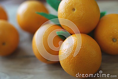 A few oranges with a heart aign made of close seeds in a gray bowl closeup on an old wooden backdround in brown with a blurred bac Stock Photo