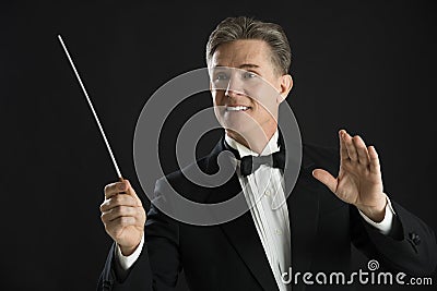 Orchestra Conductor Looking Away While Directing With His Baton Stock Photo