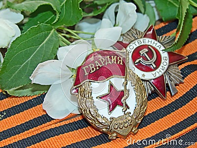 Order `Great patriotic war`, sign of `Guards` on the background of the blooming Apple tree and of the St. George`s ribbon. Stock Photo