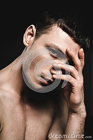 Demure man covering nose by hand Stock Photo